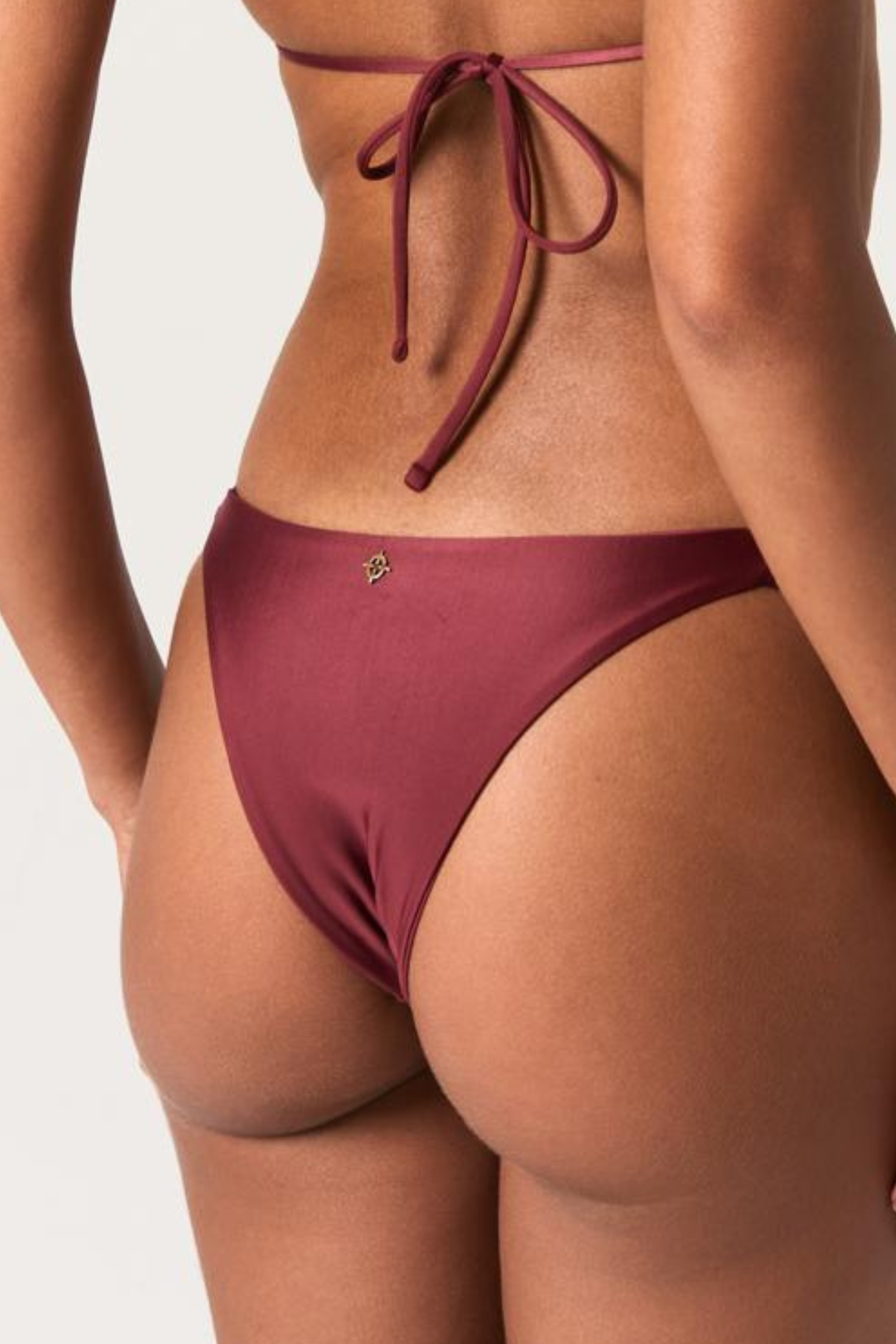 Back close up of Aurora Braded Cali Bottom bikini in bordeaux color on white model with long hair
